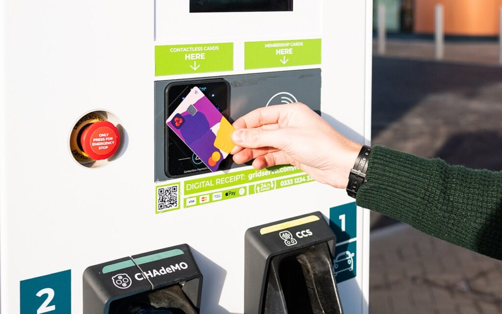 Hand holding a payment card at a GRIDSERVE charger